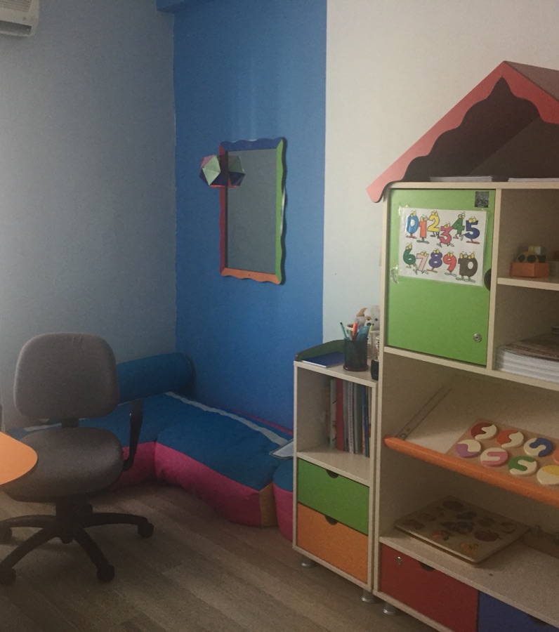 Eğitim odası: oyun evi şeklinde raf, minder ve çalışma masası